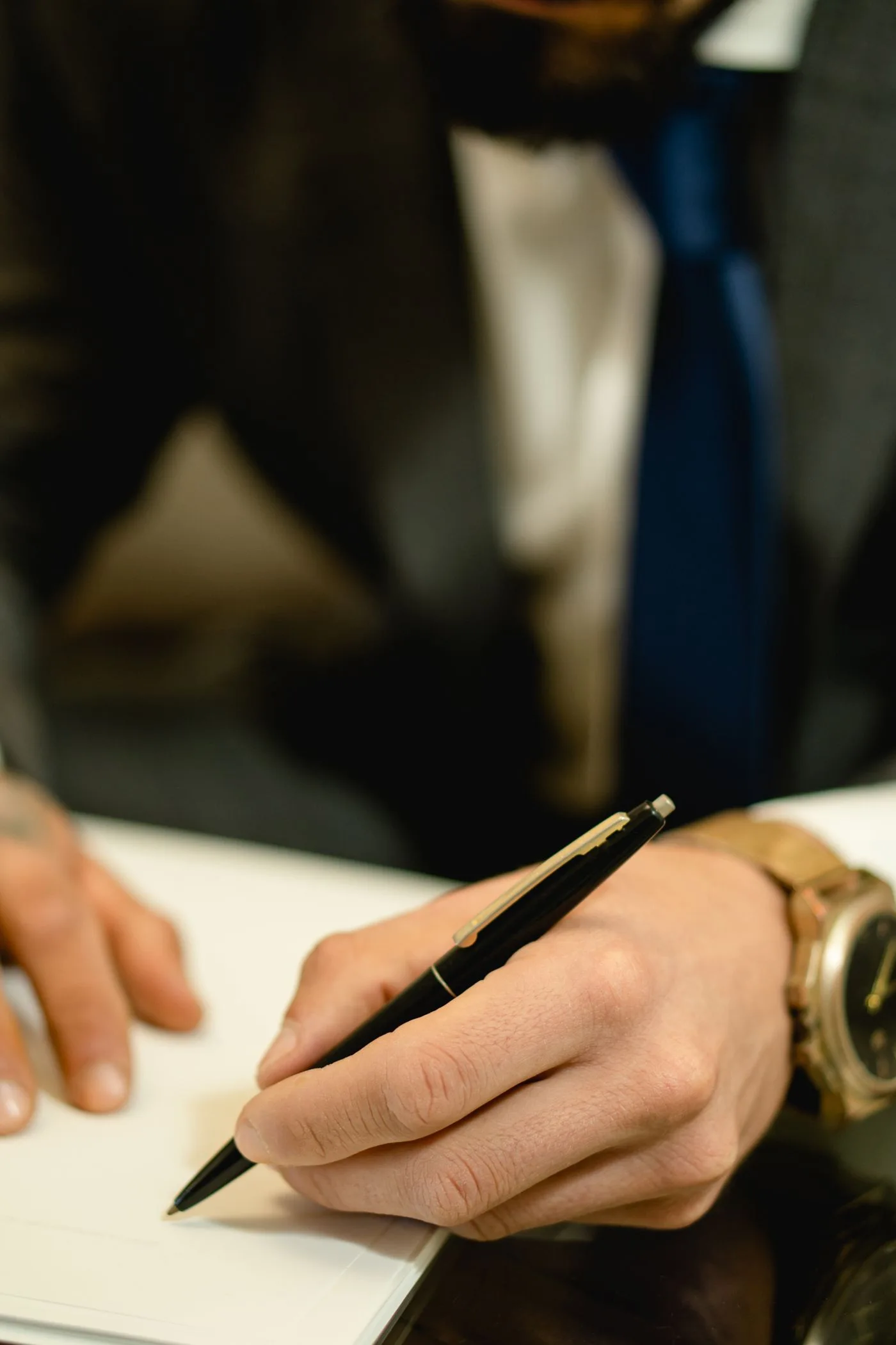 Close-up of hand signing a legal contract with a pen.