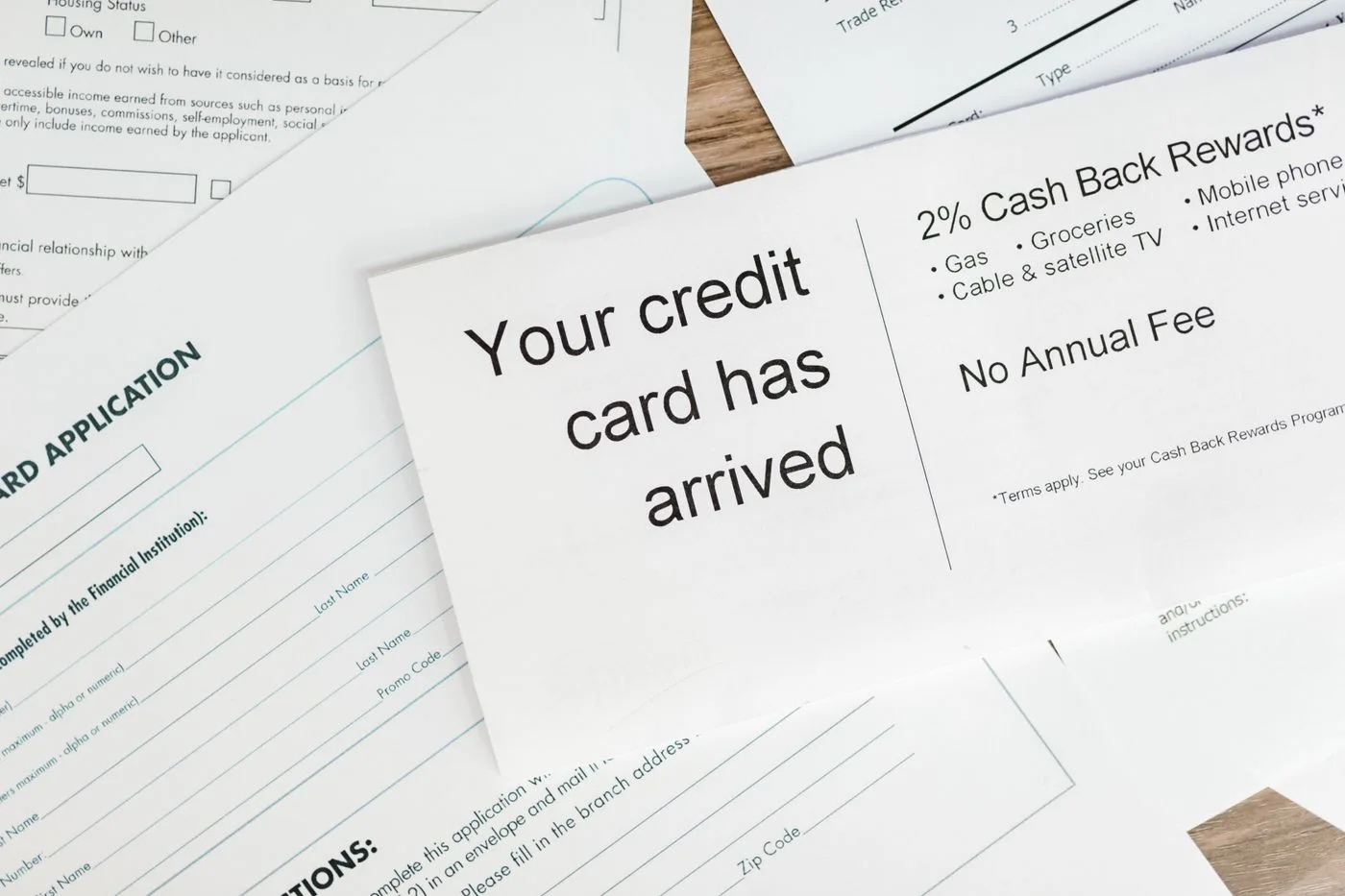 Close-up of a letter announcing the arrival of a credit card amidst financial documents.
