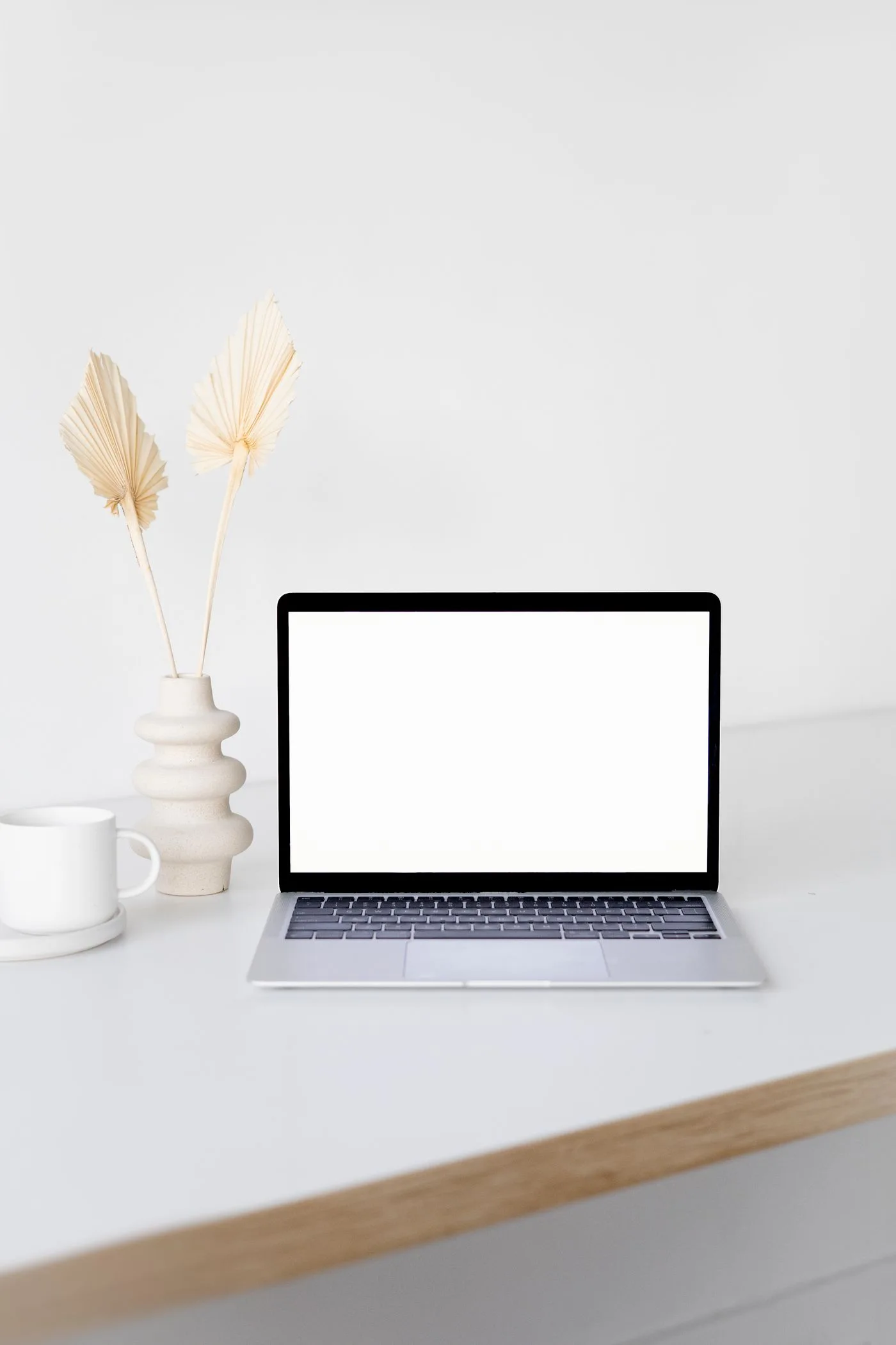 Modern minimalist workspace with a laptop featuring a blank screen, ideal for mockups.