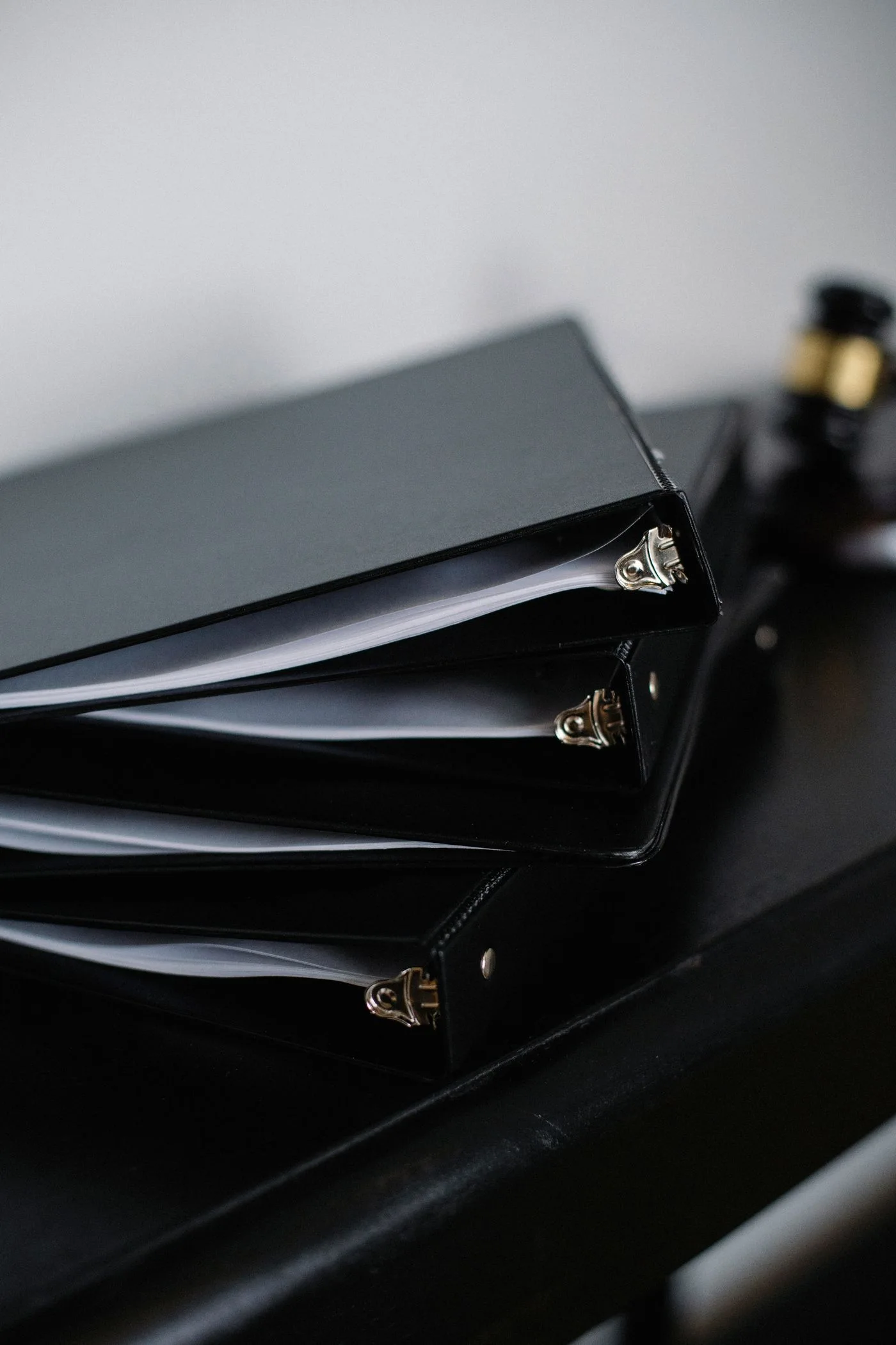 Stack of various black folders for documents on wooden table in modern office